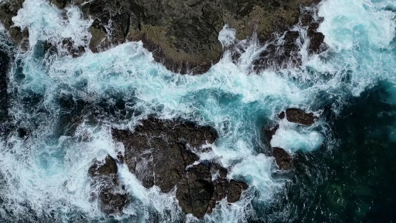 Drone aerial view showing waves crashing on rocky coastline