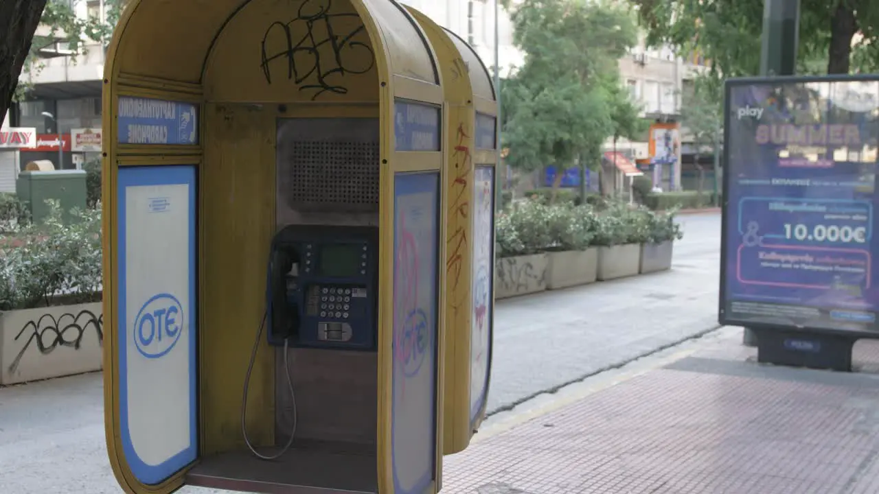 Old vandalised payphone in downtown Athens