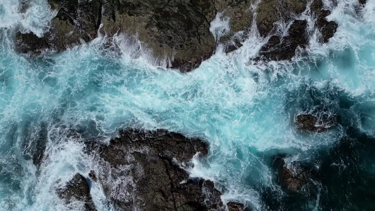 Drone rising revealing waves crashing and rocky islands