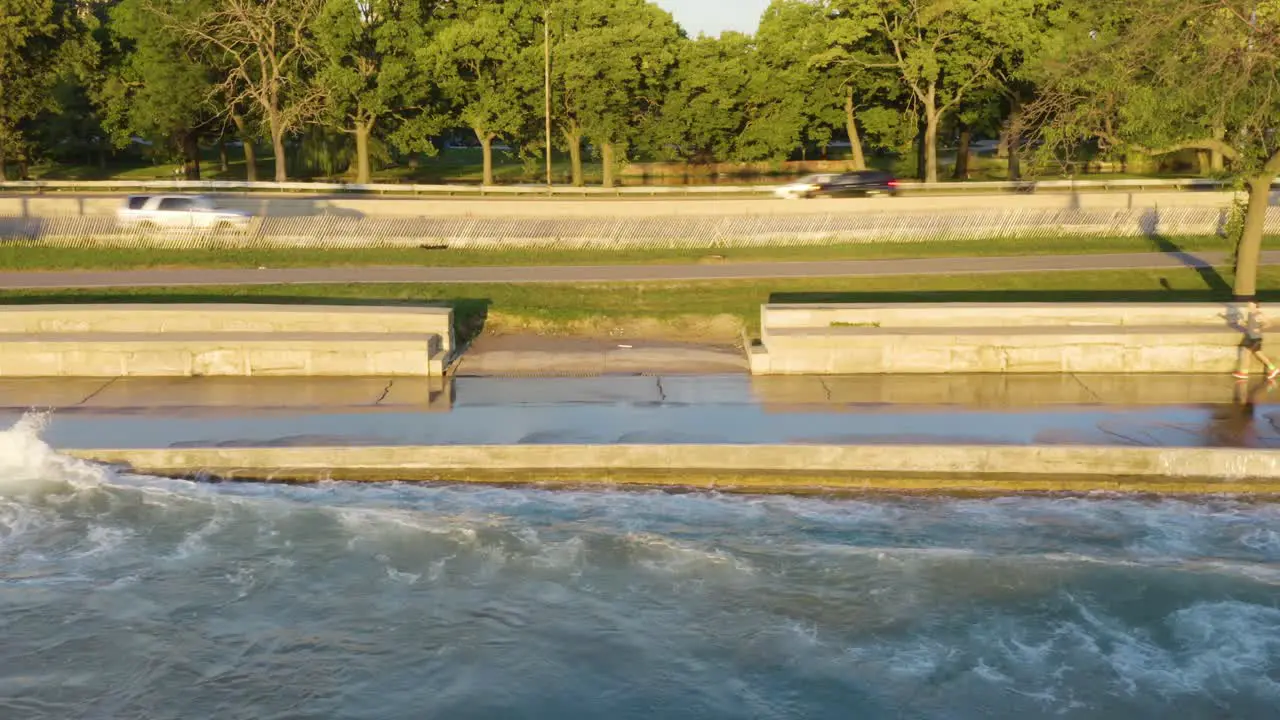 Static aerial shot of people exercising along Chicago's Lakeshore Path as waves crash onto path due to high water levels