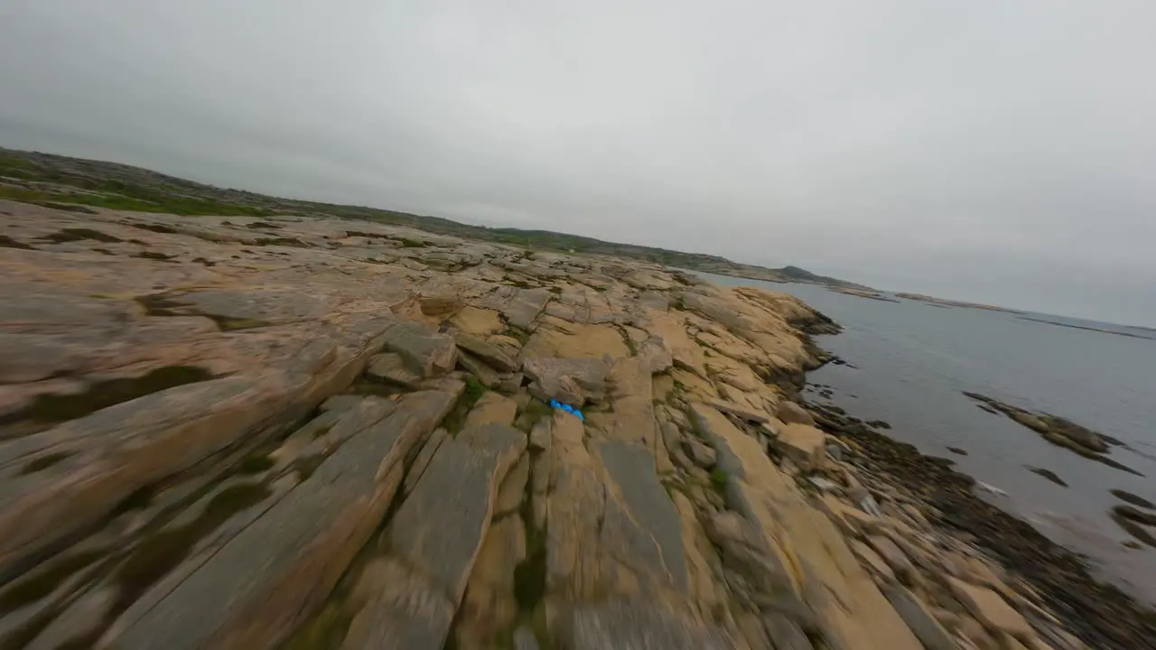 Drone flight passing low over rocky surface of Ramsvik coastline in Sweden