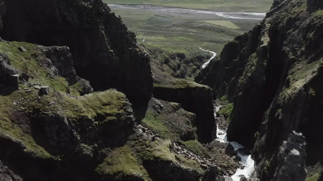 Jagged rocks in steep ravine with water flowing through aerial