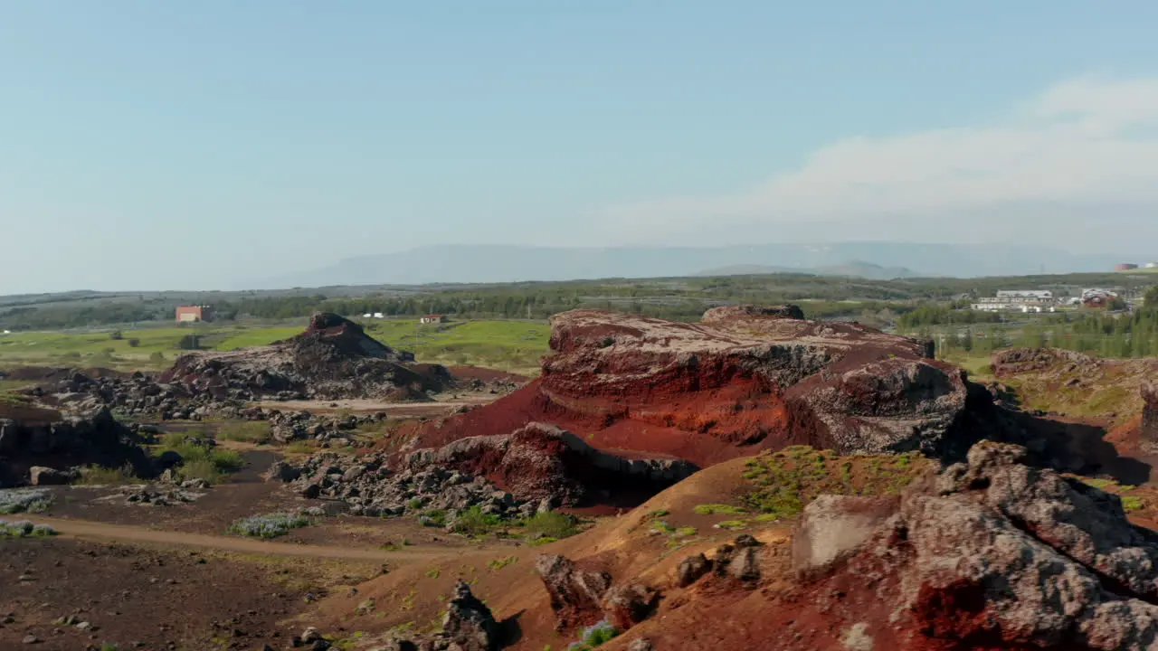 Aerial view red rock hill formations in Iceland Drone view amazing in nature orbiting around red hill in Iceland wilderness