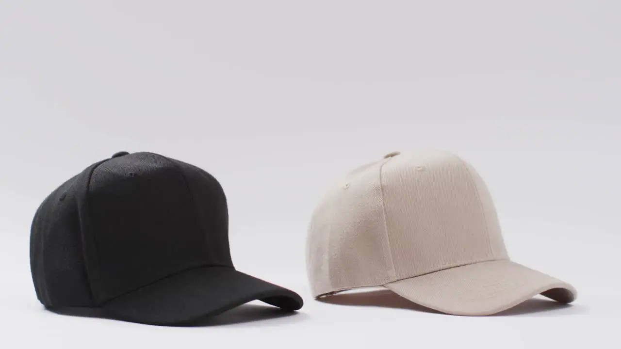 Video of black and beige baseball caps and copy space on white background