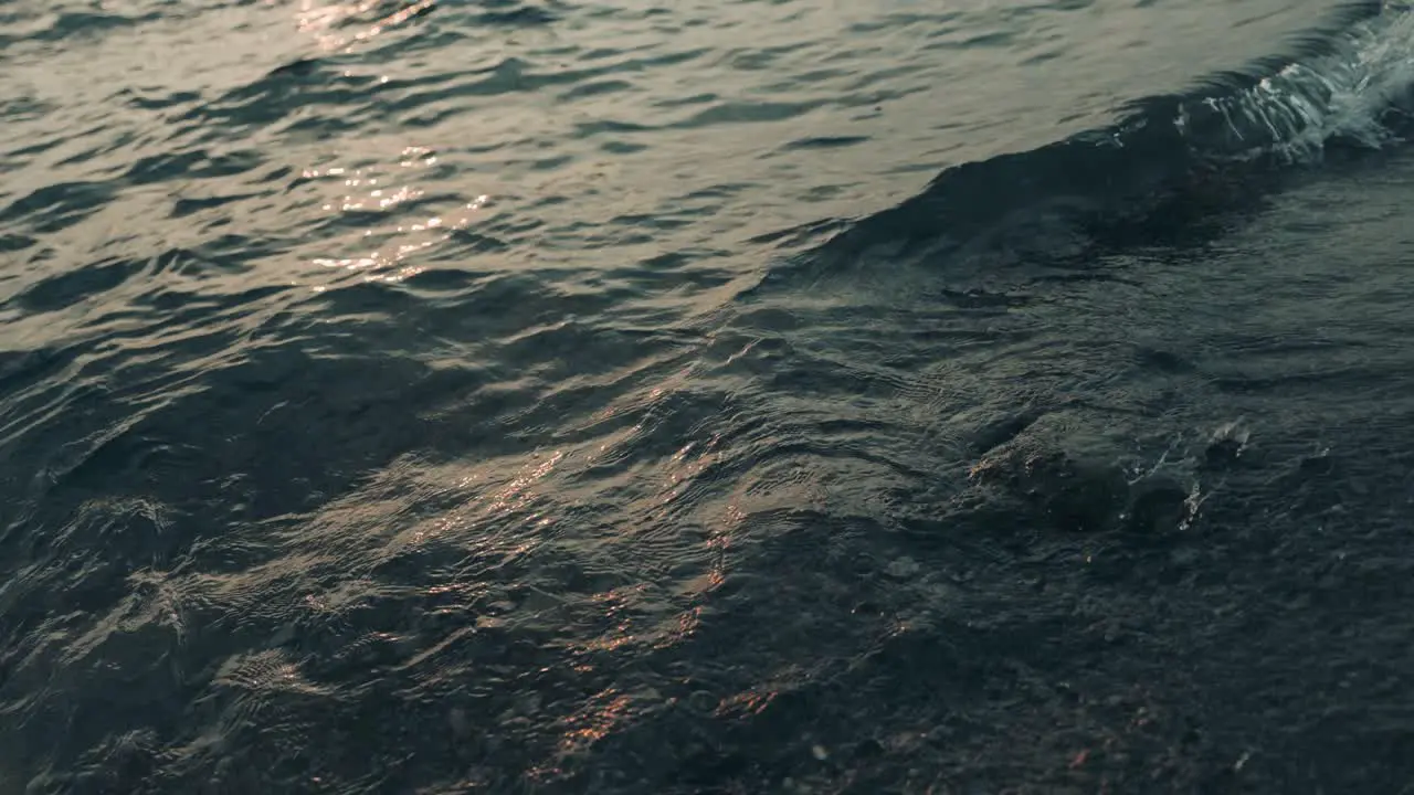 Slow motion shot of waves of wide ocean with sun refection during beautiful sunrise in background