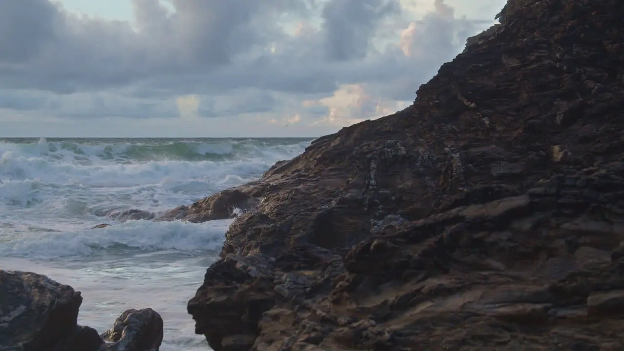 Tide surges in as waves crash on rocky shoreline slow motion