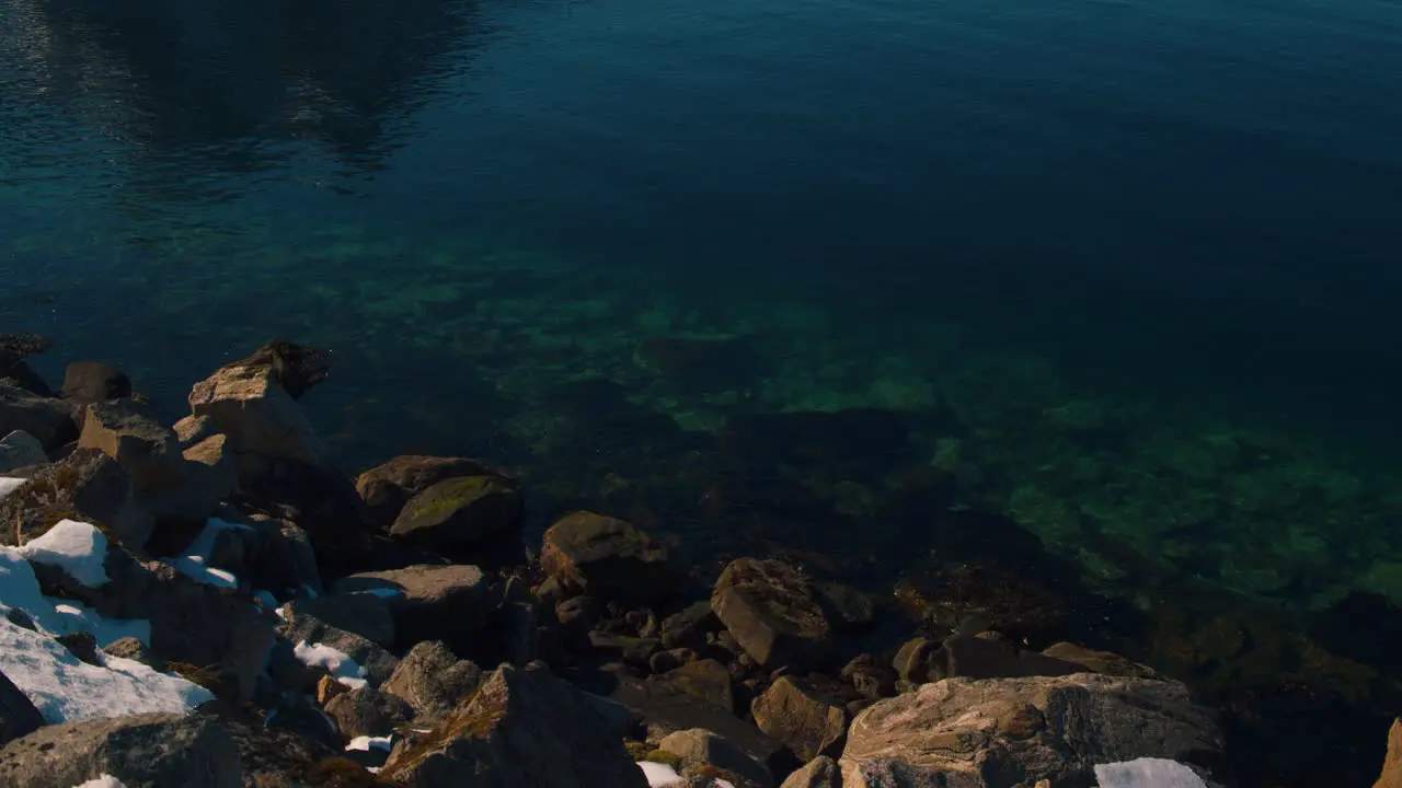 Cinematic tilt up shot from a fjord to mountains in Norway