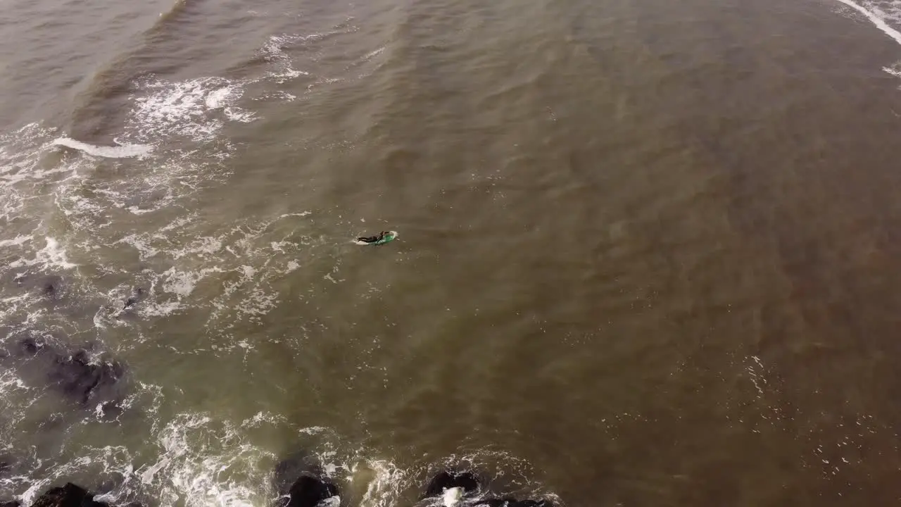 aerial view of a surfer entering the rough seas of the Atlantic Ocean at Punta del Este in Uruguay