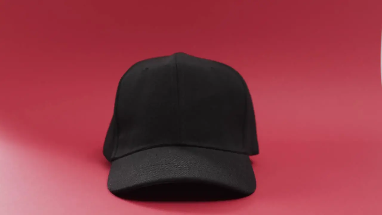 Video of black baseball cap and copy space on red background