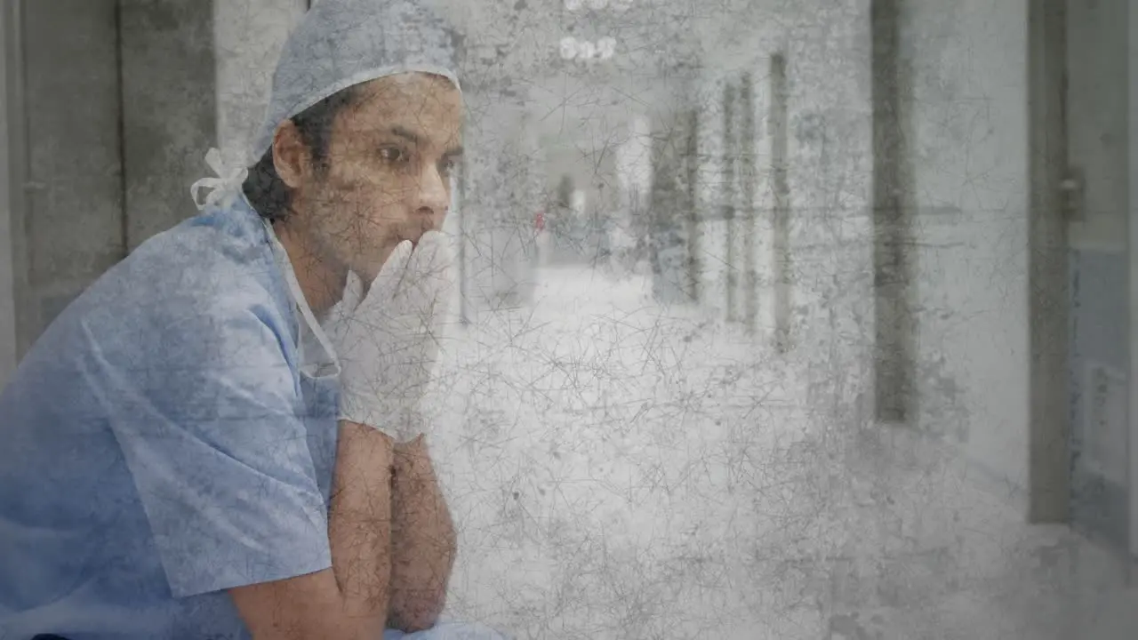 Textured scratched overlay against stressed caucasian male health worker sitting at hospital