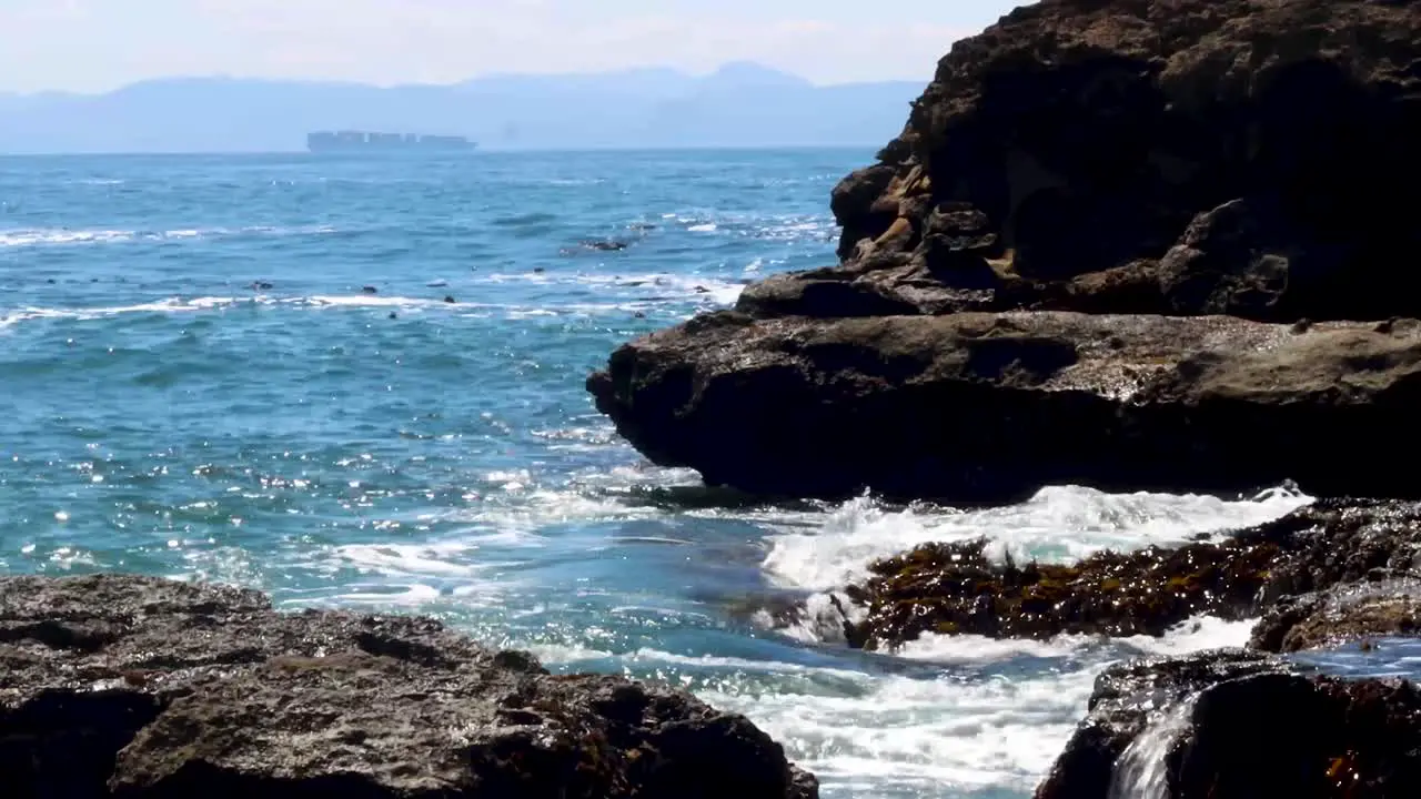 Big tide with rugged rocks and mountains visible in the distance