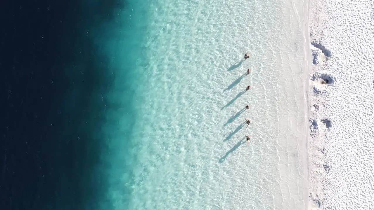 Drone aerial top view of people silhouettes in a turquoise lagoon in Fraser Island Australia