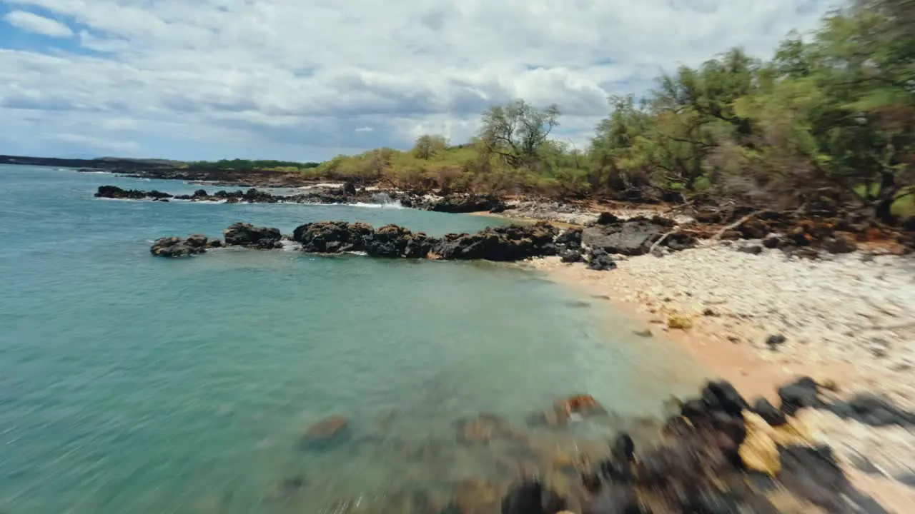 Fast and low FPV drone video flying over volcanic lava rock beach in Maui Hawaii