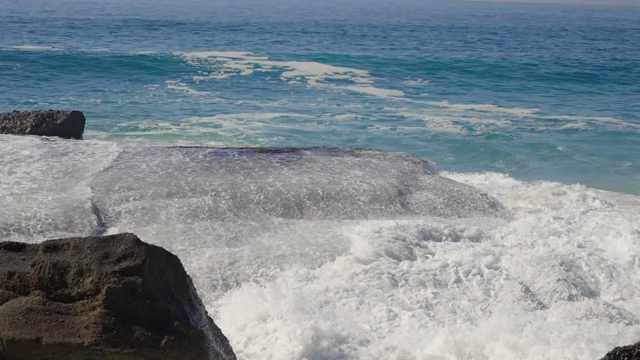 Sea water washing over large flat boulders along the coast