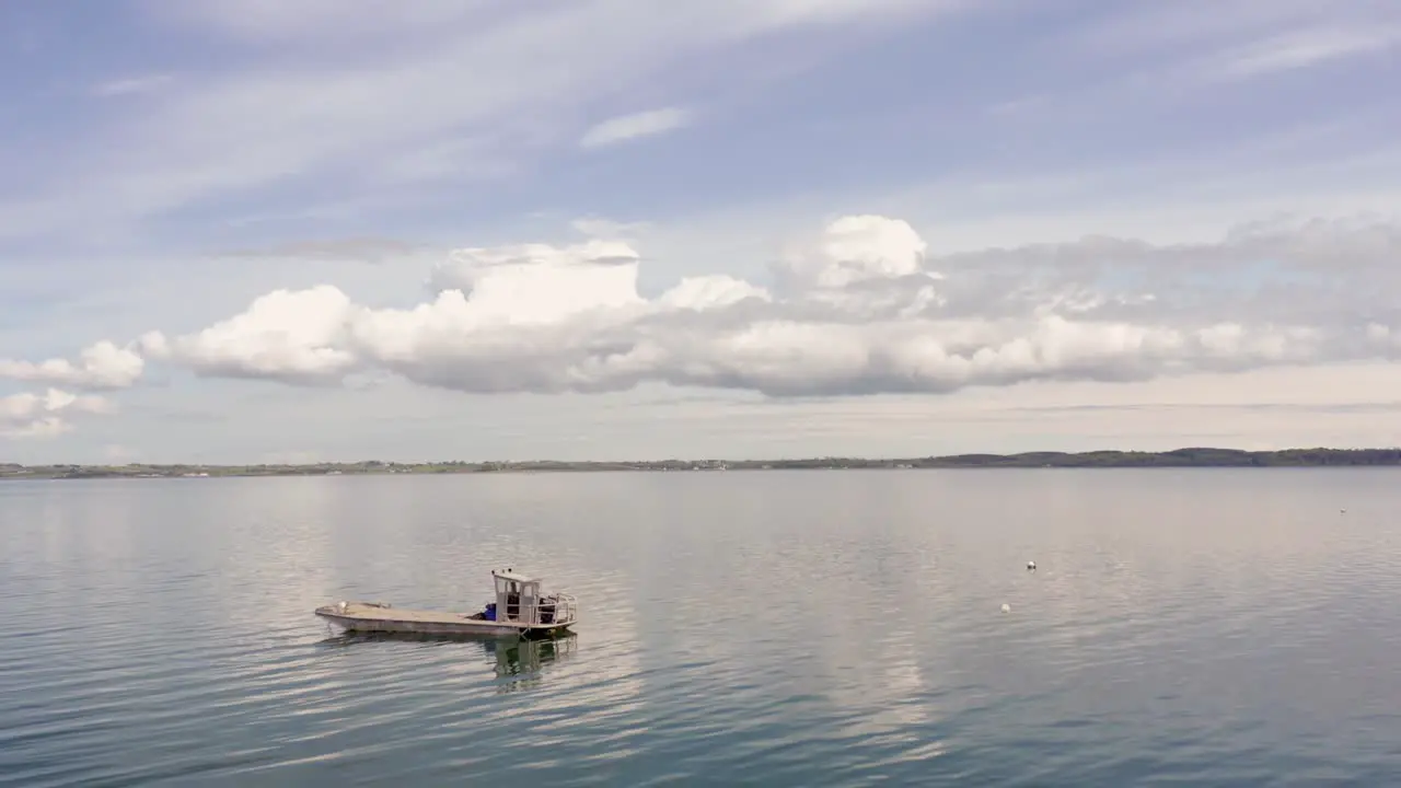 Boat on water drone reveal clouds and blue sky