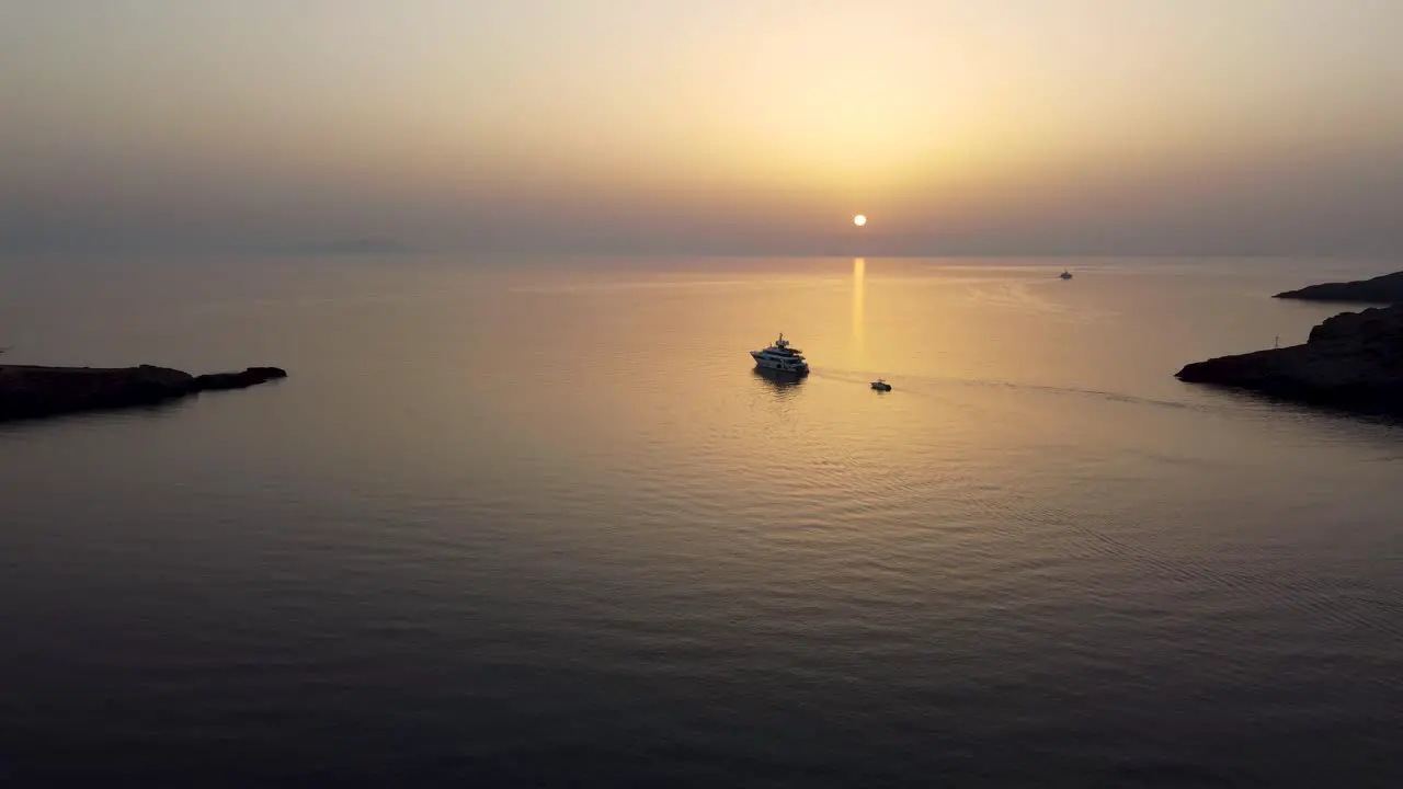 A mesmerizing aerial shot of the sea in Loutra Kythnos during sunrise following a yacht