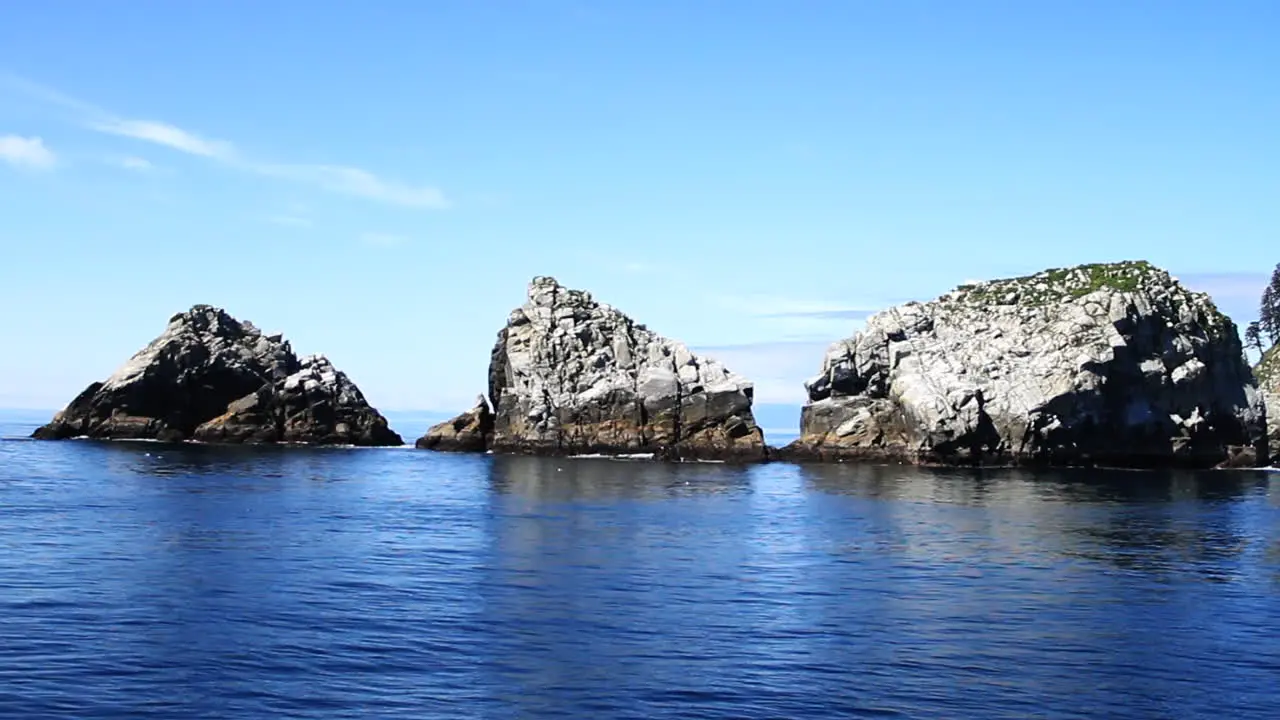 Three Rock Islands Reflect off of Calm Beautiful Blue Ocean