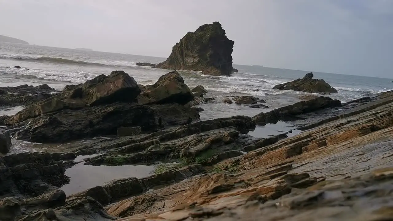 The tide coming in around stones in a pebble beach in Broad Haven West Wales in early evening