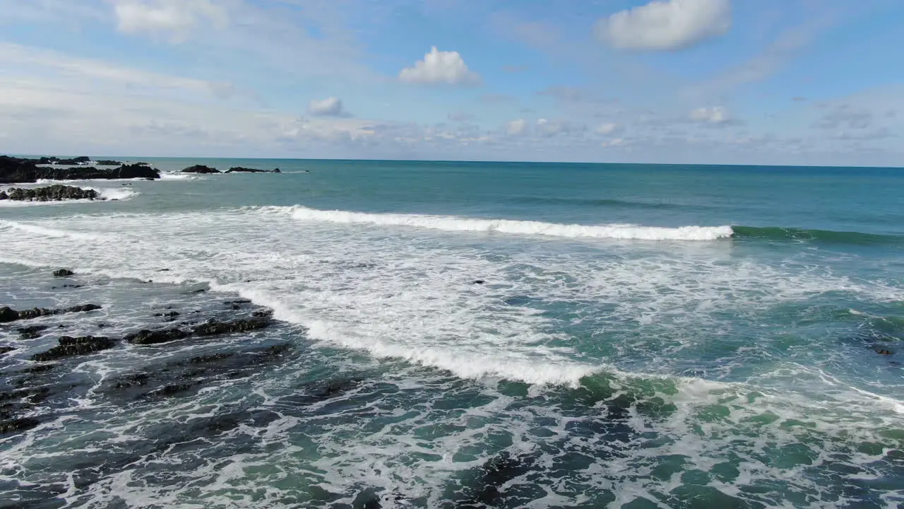 Aerial coastal shot of the waves crashing in the sea at Spekes Mill beach in Devon