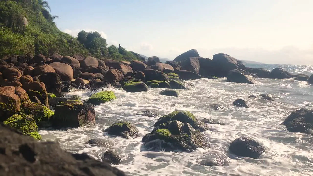 Paradisiac beach with rocks and waves at sunny day