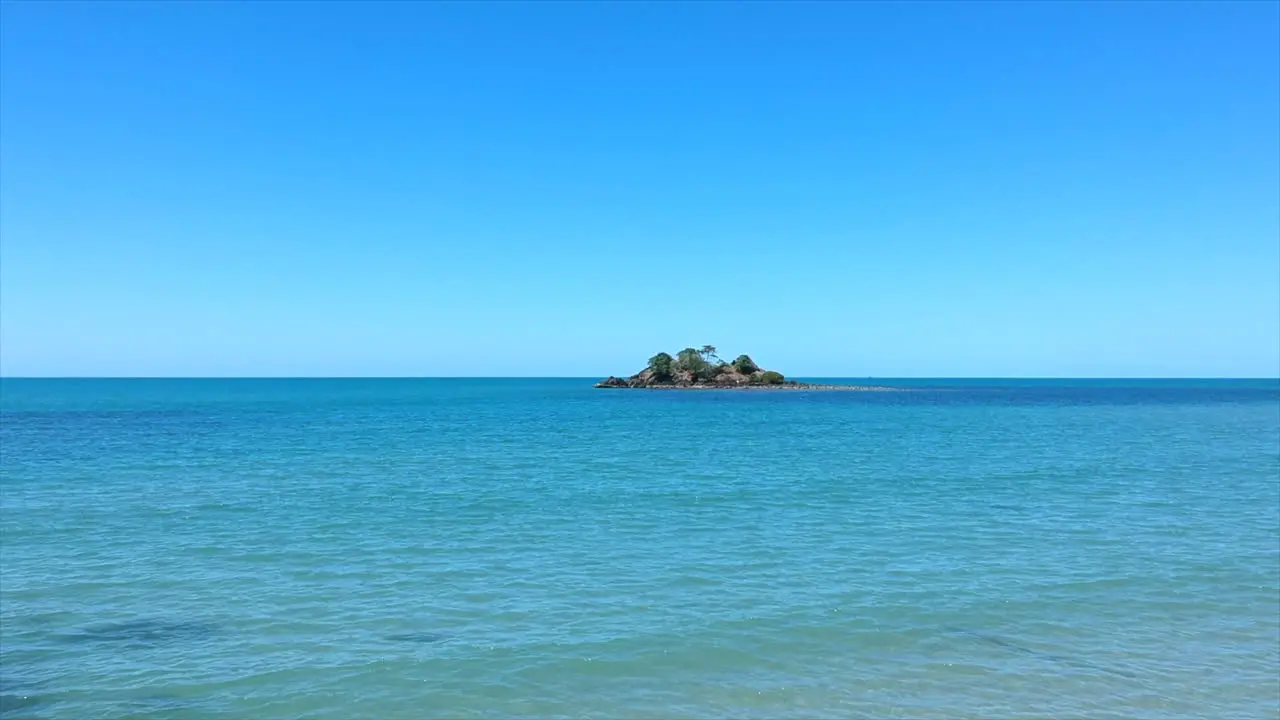 Aerial Drone flying towards a small remote island out to sea in Tropical Queensland Australia