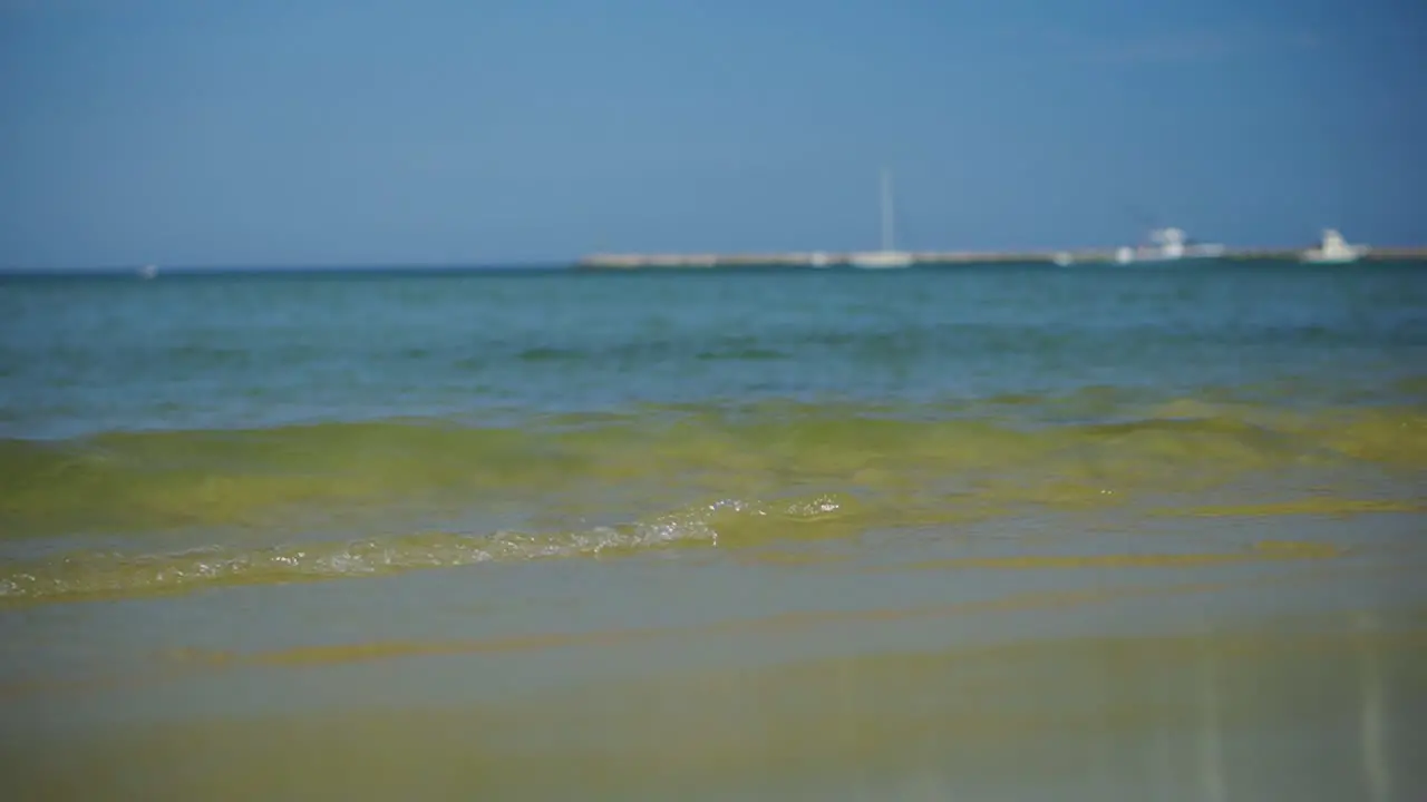 Waves crashing on a tropical beach in the summertime with crystal clear turquoise water