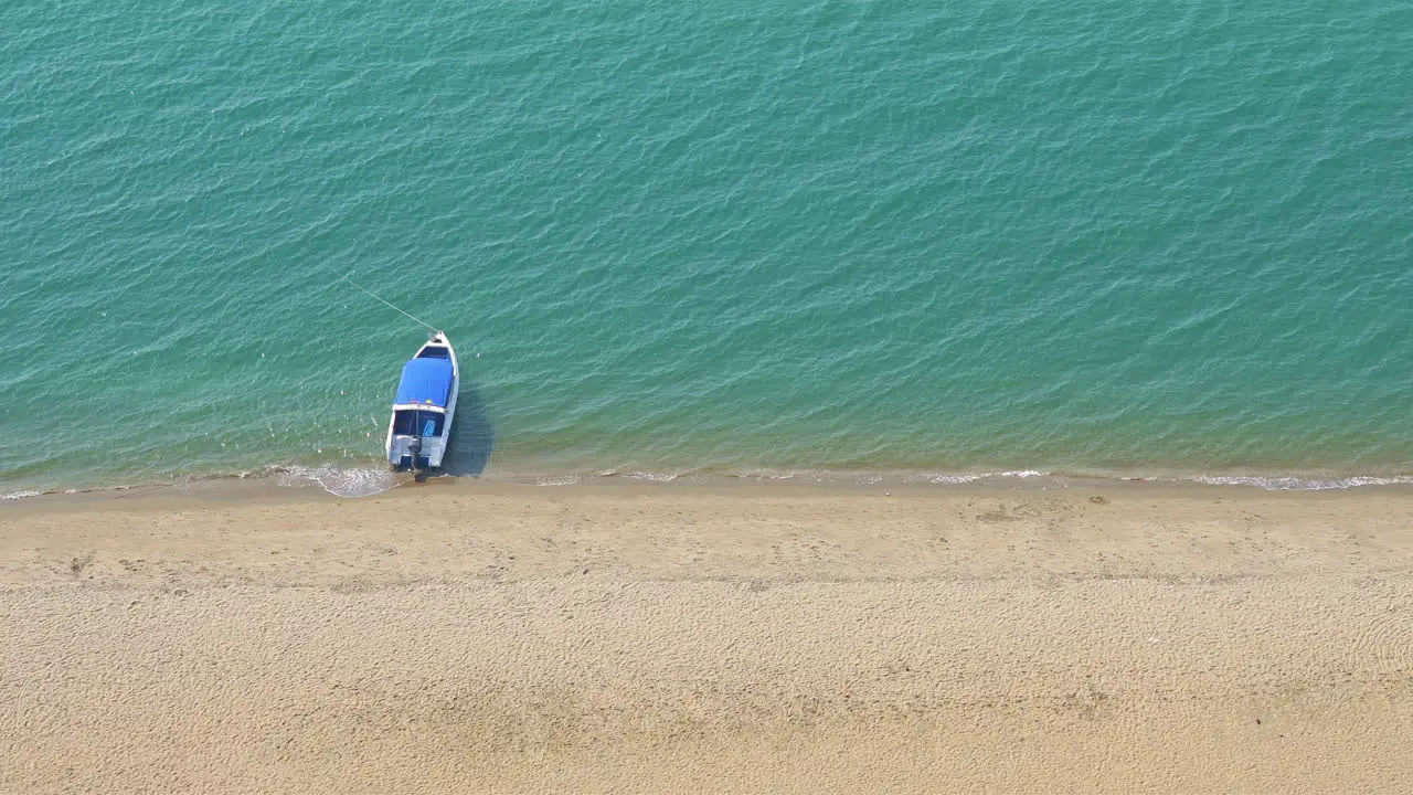 Boat near the sandy beach from top view