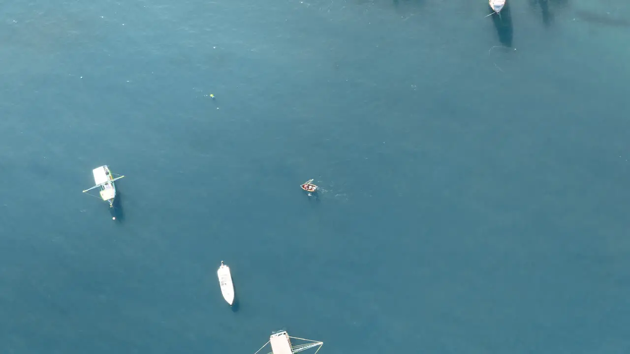 Approaching from the top by drone a small fishing rowing boat in the ocean