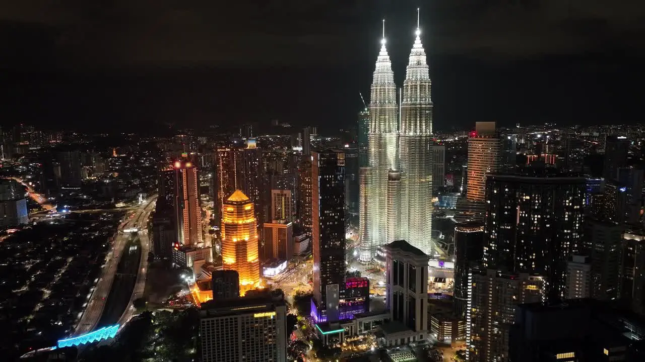 Aerial night drone shot of the city of Kuala Lumpur with the light up Petronas Towers