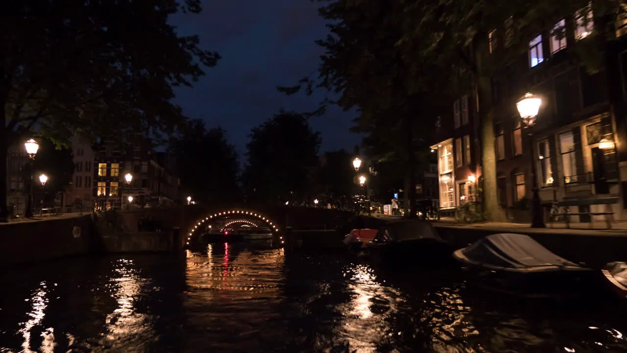 Timelapse view of cityscape during river cruise at night Amsterdam Netherlands