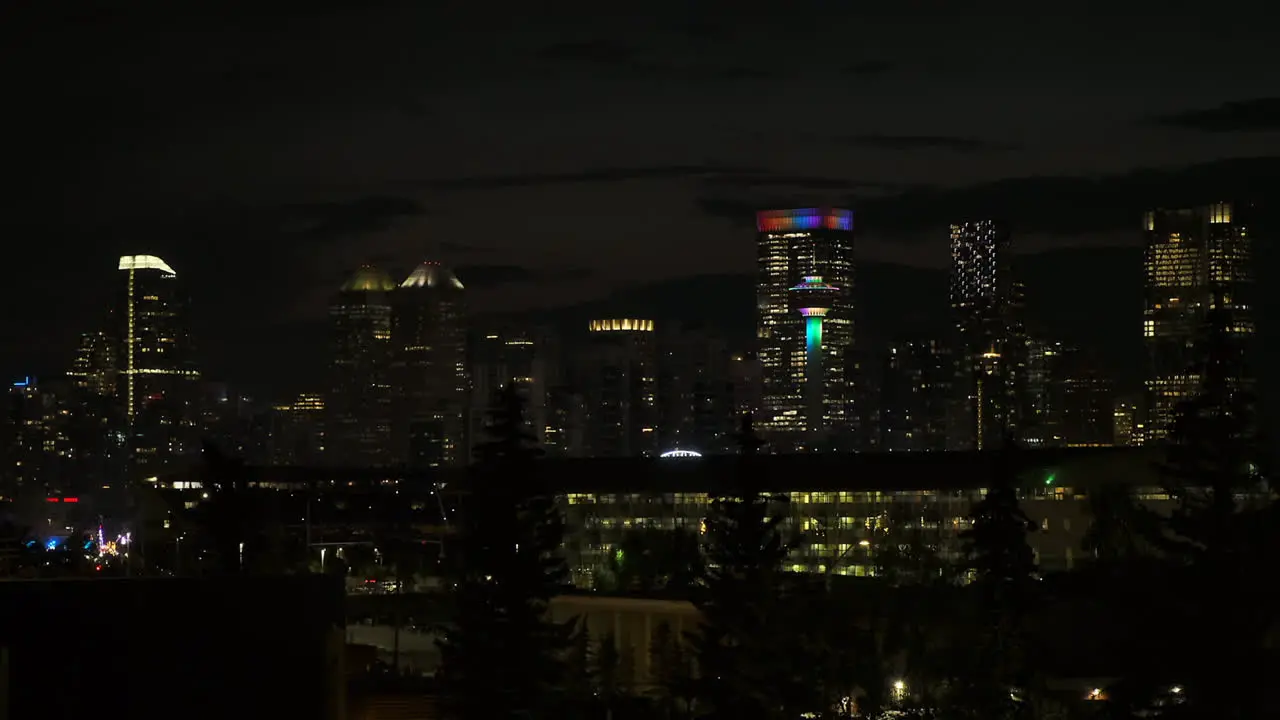 Calgary Tower and downtown skyscrapers lit up on dark city night