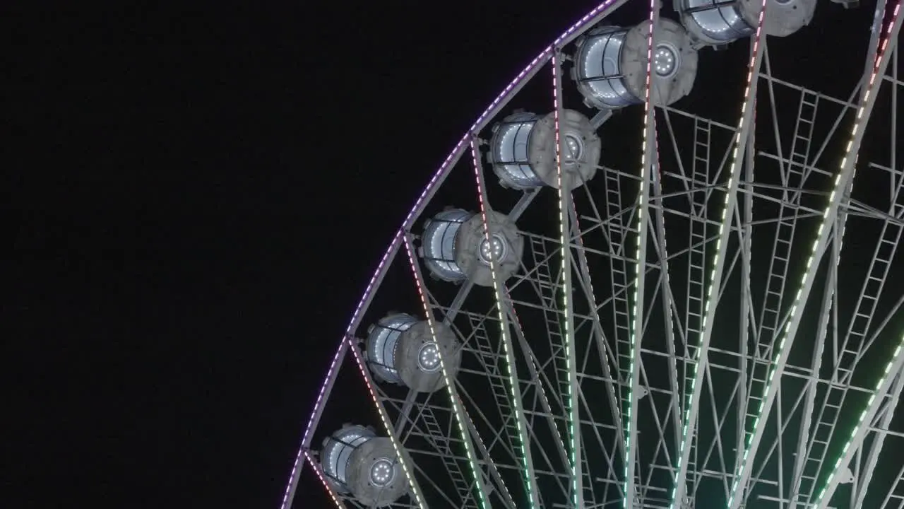 ferris wheel at night time illuminated with led lights handheld shot slowly moving