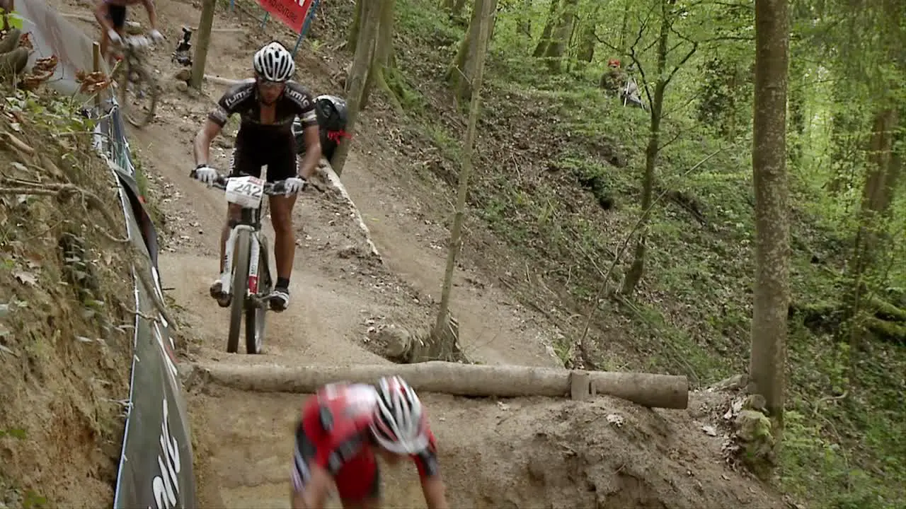 Racing bicyclists jump over an obstacle in the path