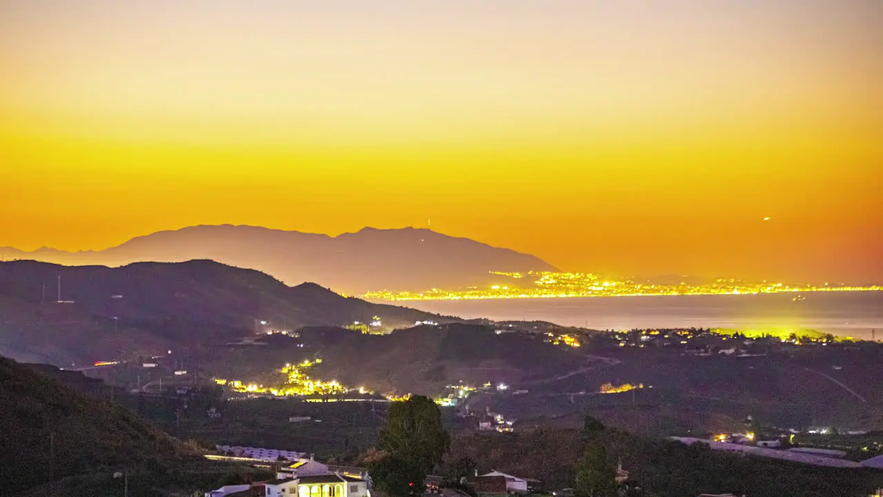 Malaga Spain time lapse transition night to day mountainous region orange sky