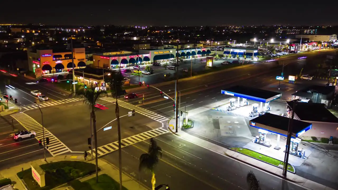 aerial time lapse of Chevron gas station at an intersection at night with cars and light streaks