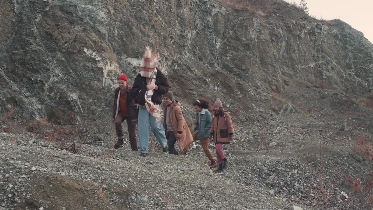 Grupo De Amigos Adolescentes Están Hablando Y Caminando Por Un Sendero De Montaña En Un Día Ventoso