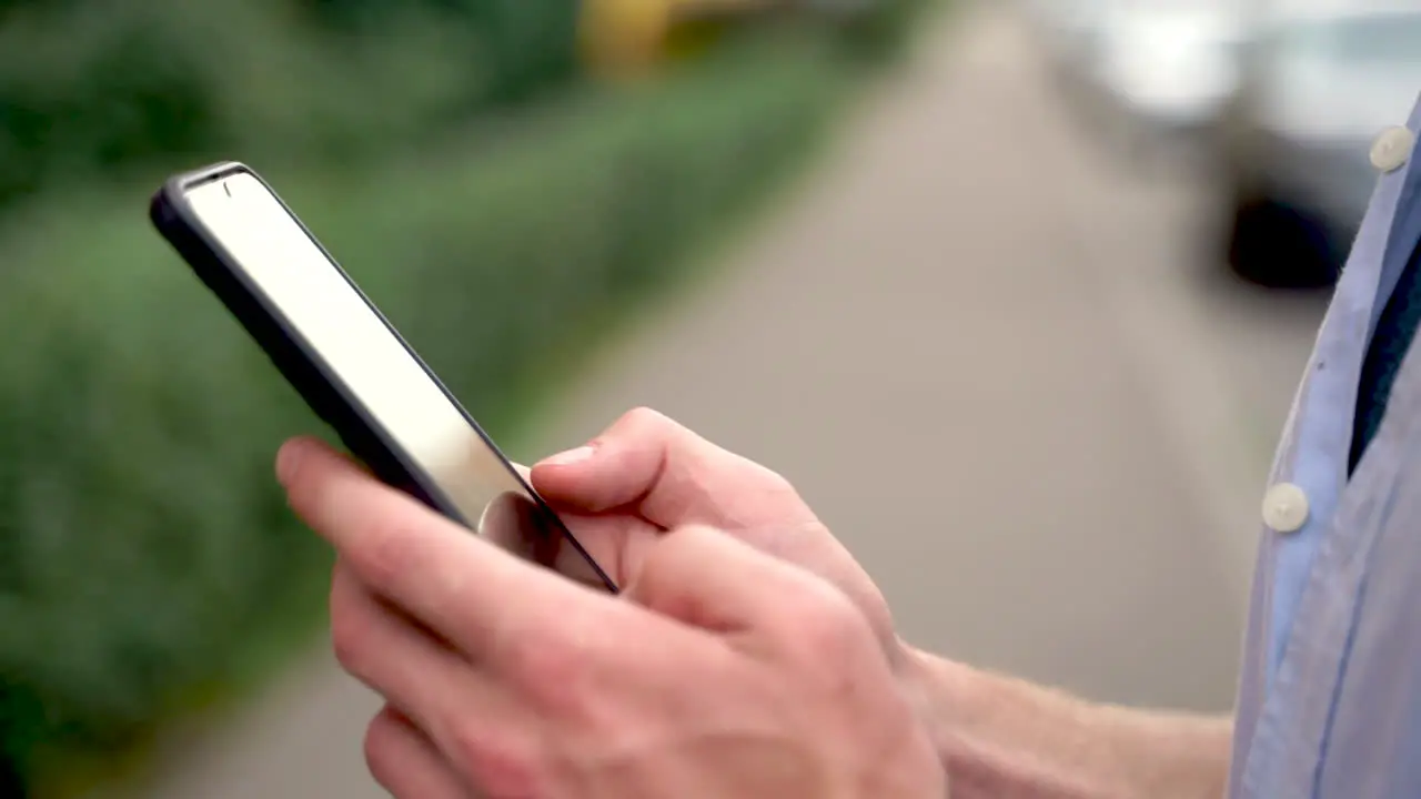 Primer Plano De Un Hombre Usando Su Teléfono Inteligente Y Sonriendo Al Aire Libre