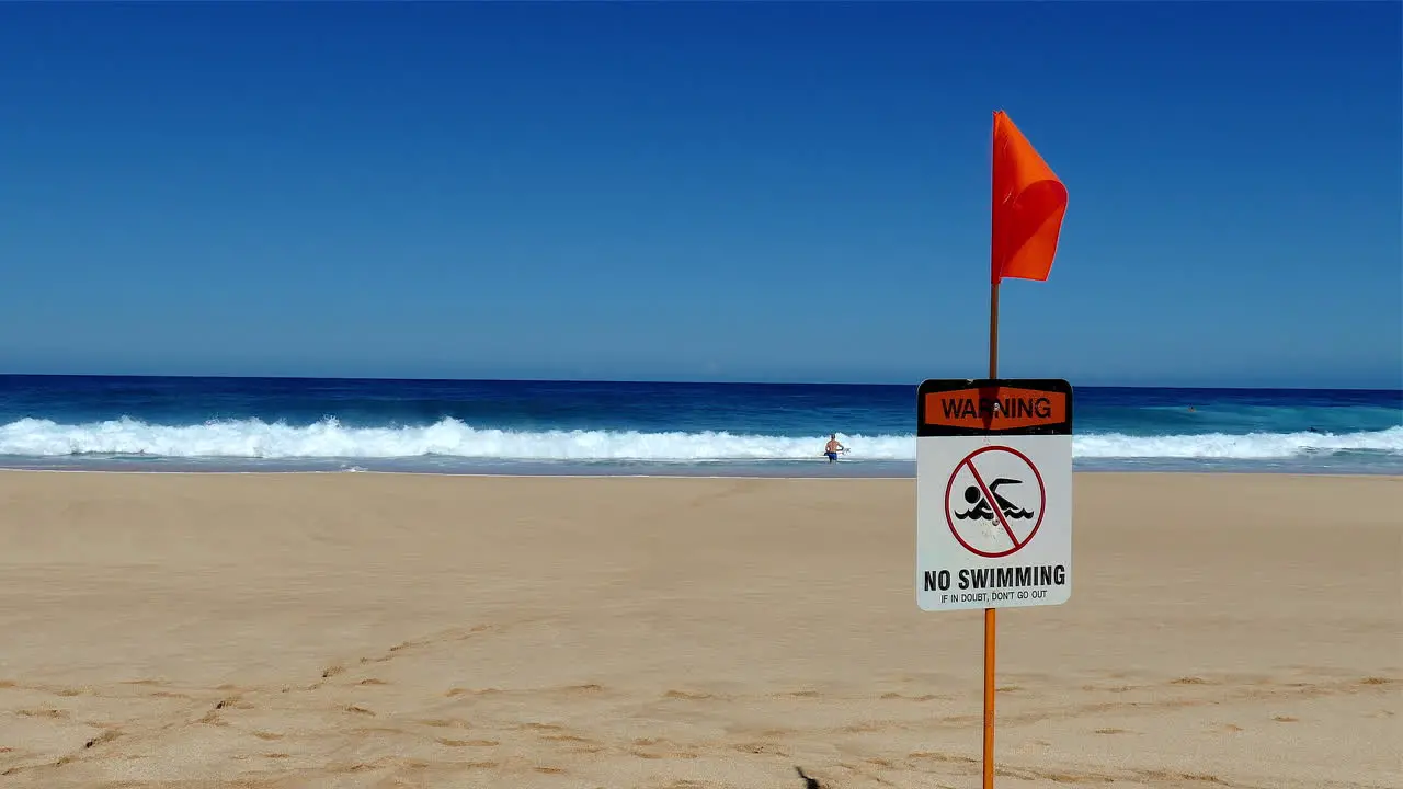 Video footage of a "No Swimming" sign posted at the beach on the North Shore of Oahu Hawaii