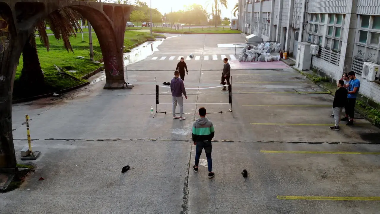 Aerial video of group of friends playing soccer tennis with a net