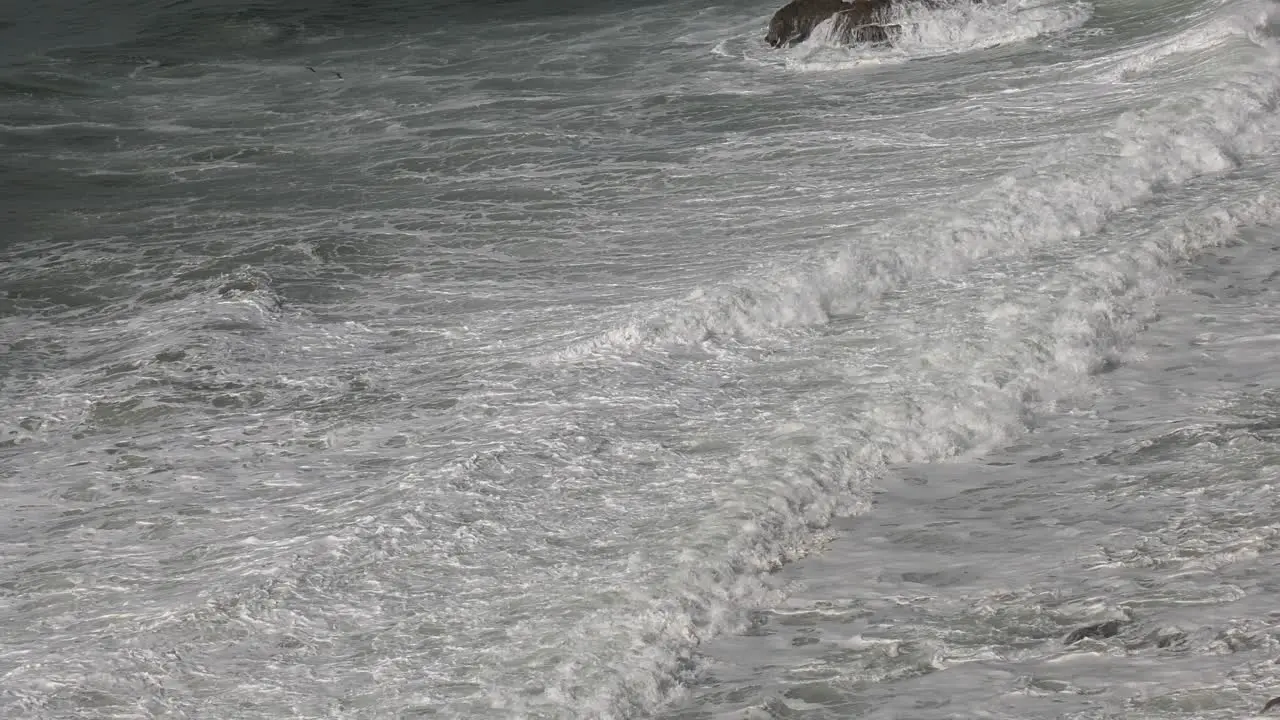 waves collide with beach at high tide