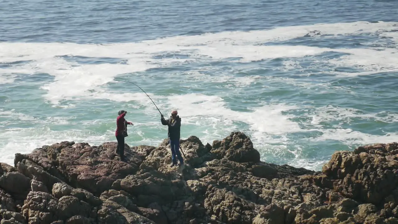 Local fisherman catches and lands fish on rocks from the ocean