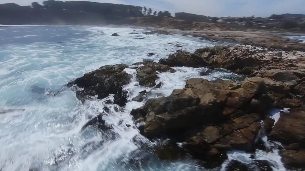 Rough sea waves crashing on rocky shore dramatic FPV aerial view