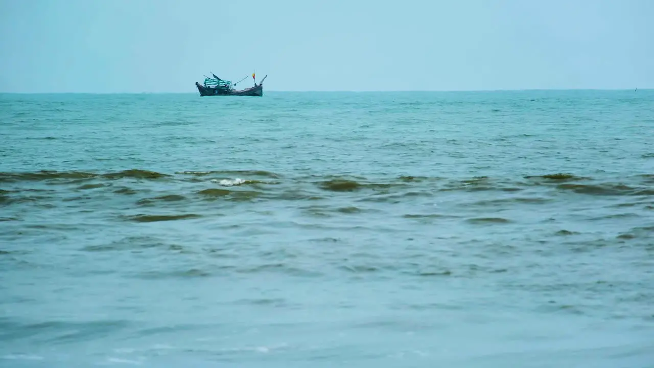 Fishing trawler at sea seen from the beach