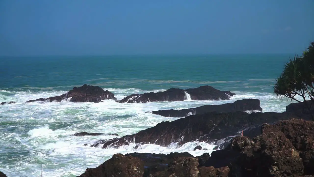 Ocean waves hitting rocky shore of coastline Indonesia