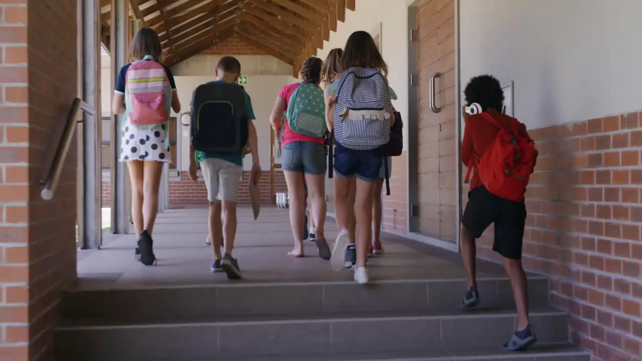 Group of kids with school bags walking in the school corridor