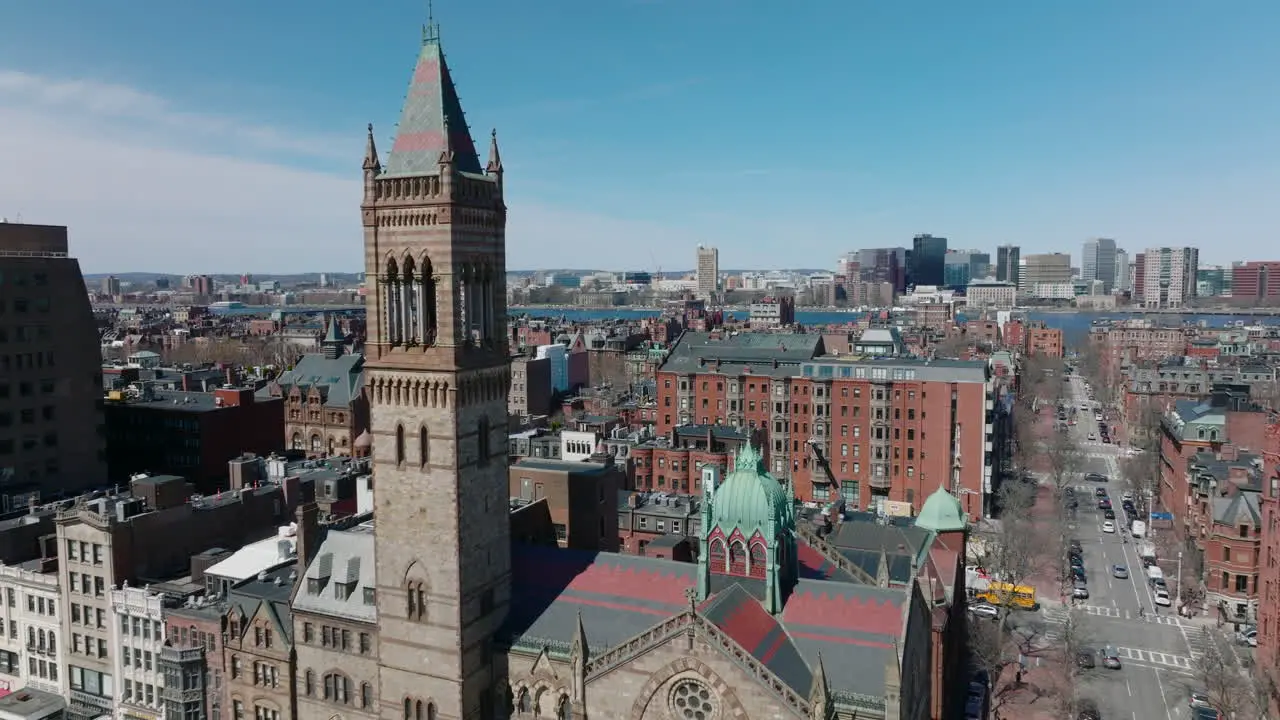 Fly around tall tower of Old South Church Revealing panoramic view of red brick houses in residential urban neighbourhood Boston USA