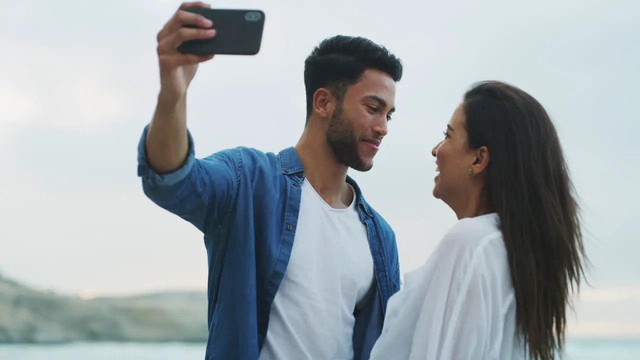 an affectionate young couple taking selfies