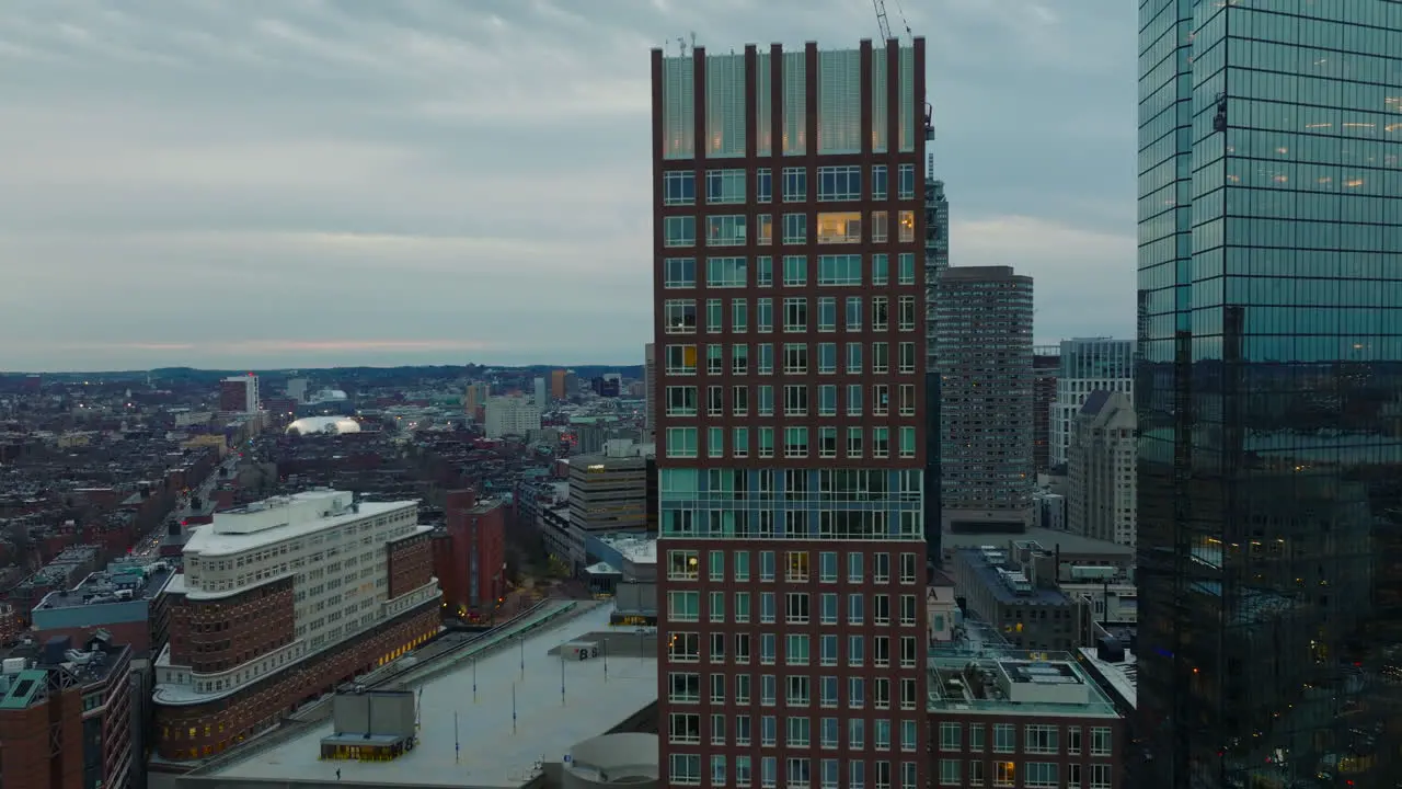 Elevated view of downtown buildings at dusk Fly around modern tall skyscrapers with glossy glass facades Boston USA