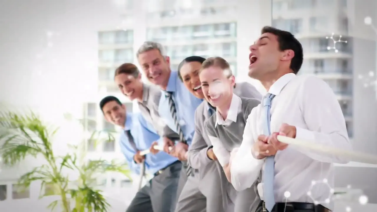 Molecular structures floating against diverse businesspeople pulling a rope together at office