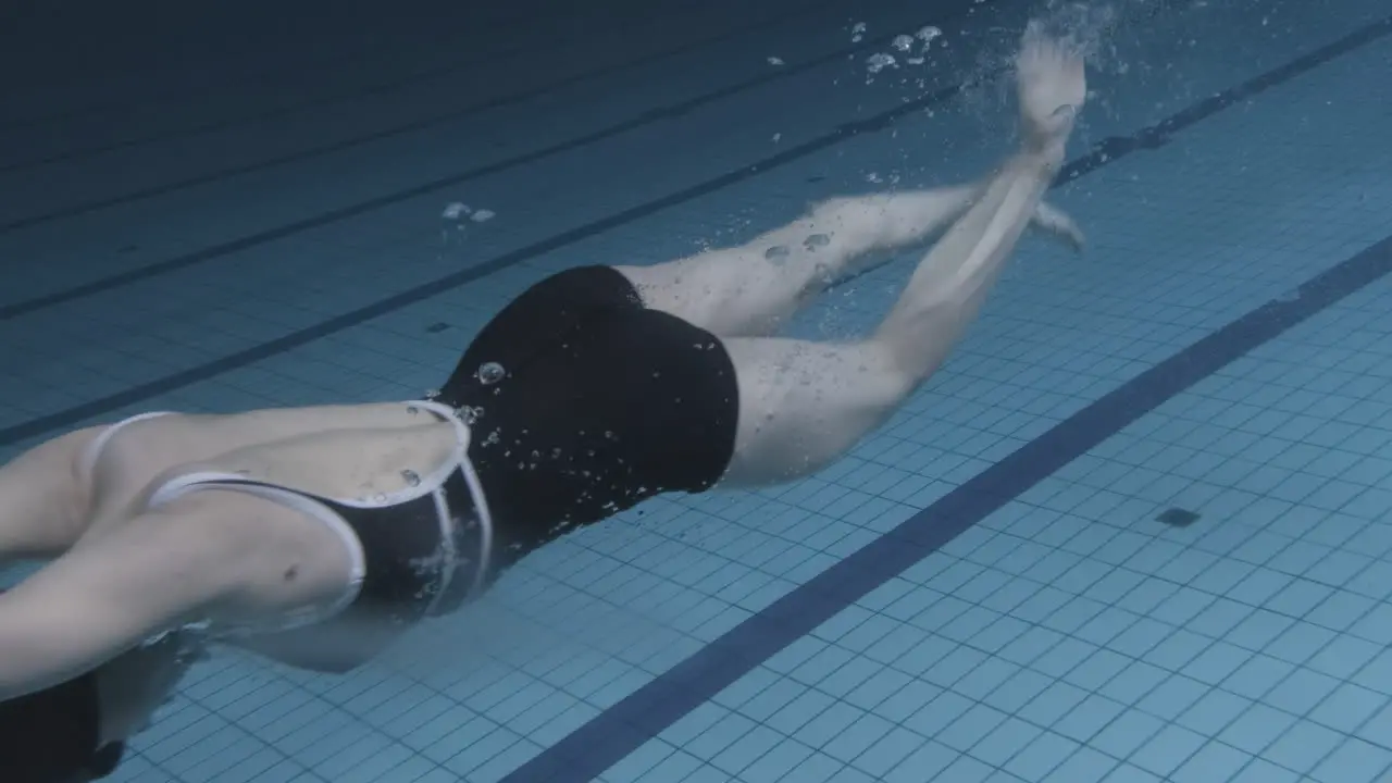 Underwater Shot Of A Young Female Swimmer Jumping Into The Pool And Diving In